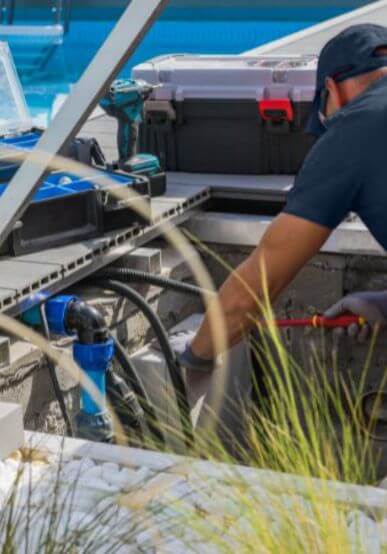 Man installing pool equipment in the pool equipment enclosure