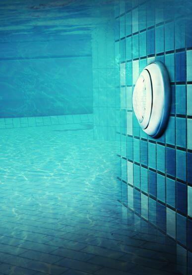 Pool lights glowing in the water at night